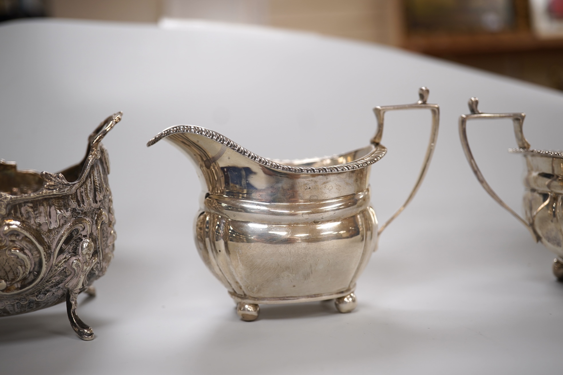 A George V silver two handled sugar bowl and matching cream jug, Z Barraclough & Sons, London, 1918, together with a late 19th century German Hanau silver sugar bowl, 10.5oz.